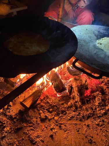 a person cooking food on top of a grill at Laattajan Pirtti vuokramökki 1-5 henkilölle in Hyrynsalmi