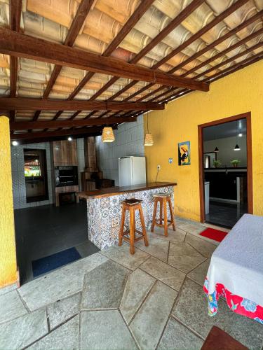 a patio with a kitchen with a counter with stools at chacara sombra da mata01 in Pirenópolis