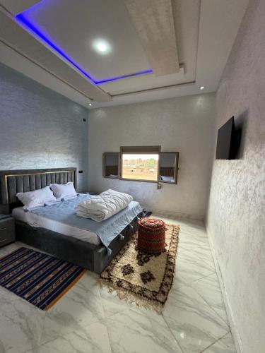 a bedroom with a bed with a blue ceiling at Riad Restaurant Mifis in Rissani