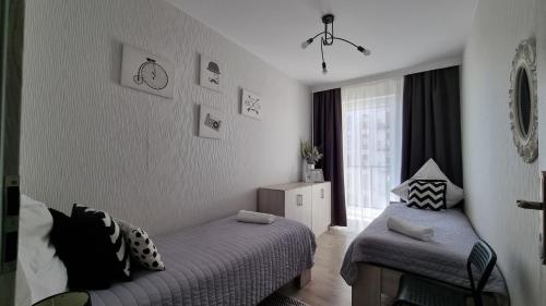 Postel nebo postele na pokoji v ubytování Q Apart Gold- 3 pokojowy klimatyzowany apartament przy Manufakturze z garażem Gratis, FV