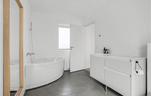 a white bathroom with a tub and a sink at Beautiful Home In Sjællands Odde in Yderby