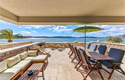 トロギールにあるAmazing Home In Trogir With Saunaのパティオ(椅子、テーブル、パラソル付)