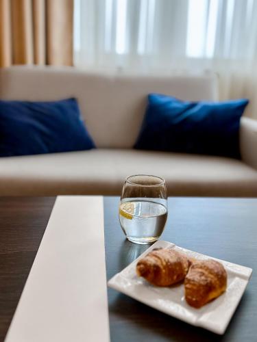a glass of water and two donuts on a table at Hotel Szafran in Czeladź