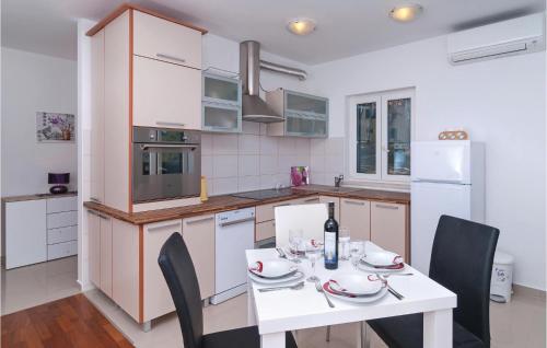 スティヴァンにあるApartment Sutivan With Sea View Viのキッチン(白いテーブル、椅子付)、キッチン(白い電化製品付)