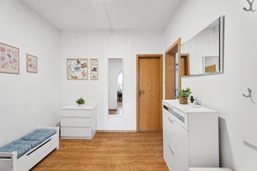Cette chambre blanche comprend un lit et un miroir. dans l'établissement Neue und helle 2 Zimmer Wohnung, nähe Veltins Arena, Home Office, kostenlose Parkplätze, à Gelsenkirchen