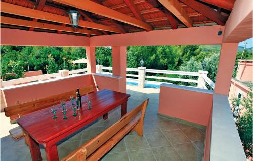 a patio with a wooden table and a bench at Holiday Home Smokvica Smokvica in Smokvica