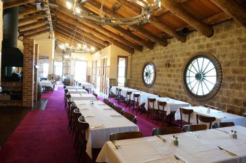 a dining room with white tables and chairs and a clock at Mahogany Park in Cranbourne