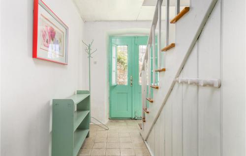 a hallway with a blue door and a staircase at 3 Bedroom Lovely Home In Nerezine in Nerezine