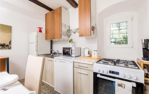a kitchen with a stove and a microwave at 3 Bedroom Lovely Home In Nerezine in Nerezine