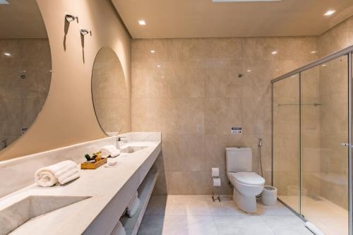 a bathroom with a sink and a toilet and a shower at Pousada Terramare in Guapé