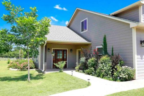 a house with a green yard with a tree at Hailey's Cottage on Small Farm-16 minutes to Silos in Bellmead
