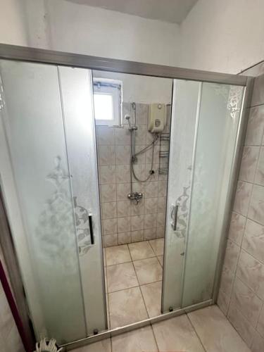 a shower with a glass door in a bathroom at Kesen Cappadocia House in Ürgüp