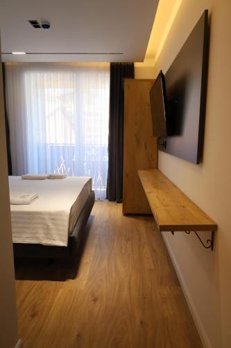 a bedroom with a bed and a tv and a window at Hotel Luna in Prizren