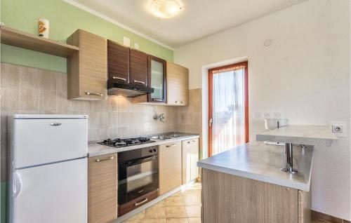 kuchnia z białą lodówką i drewnianymi szafkami w obiekcie 6 Bedroom Amazing Home In Bratulici w mieście Hreljići