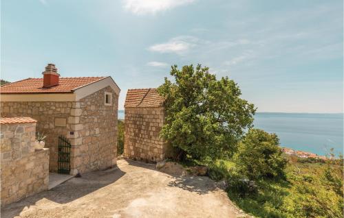 a stone house with a view of the ocean at Two-Bedroom Holiday Home In Tucepi in Tučepi