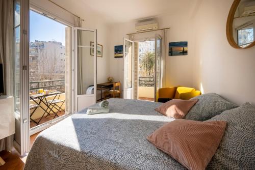 une chambre avec un grand lit et un balcon dans l'établissement * Le Provençal * cosy flat 3 min walk from the sea, à Nice