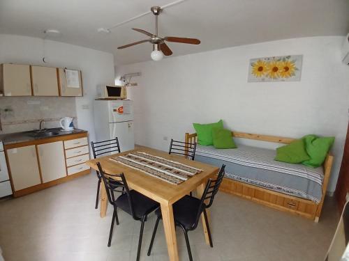 a room with a table and a kitchen with a bed at Ruta C Departamentos en Las Grutas y excursiones in Las Grutas