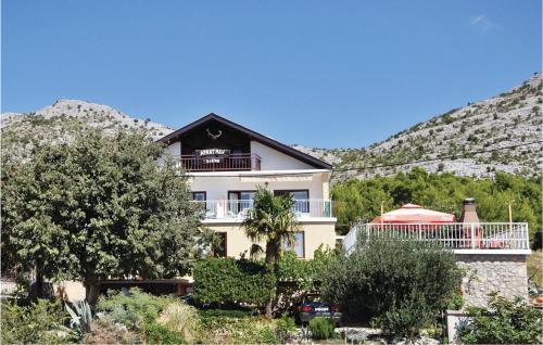 a large white house with a mountain in the background at Apartment Alojzija Stepinca Ii in Starigrad-Paklenica
