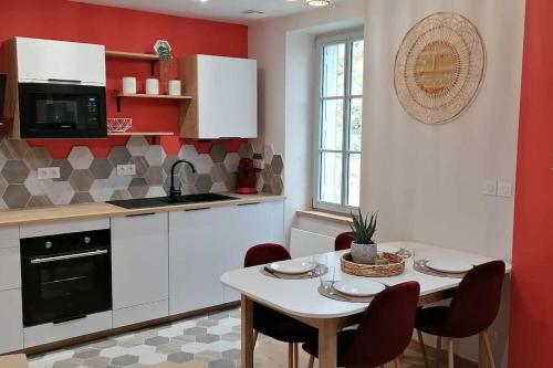 une cuisine avec une table avec des chaises et un micro-ondes dans l'établissement Appartement neuf dans Résidence, à La Bourboule