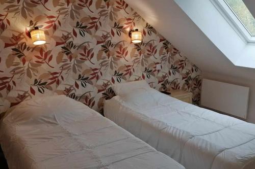 une chambre avec deux lits et un mur dans l'établissement Appartement neuf dans Résidence, à La Bourboule