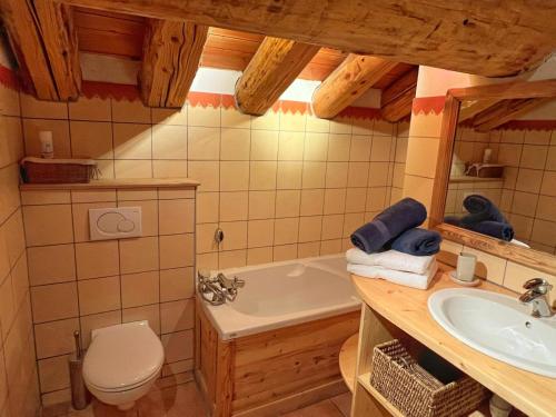 a bathroom with a tub and a toilet and a sink at Le Refuge - 5 bedroom chalet with sauna in Sainte-Foy-Tarentaise
