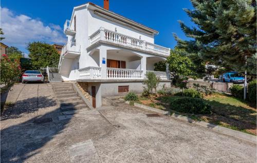 a white house with a balcony and a driveway at 1 Bedroom Amazing Apartment In Krk in Krk