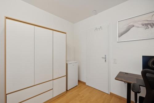 a room with white cabinets and a desk at Pearlstay - City Center Workplace Balcony Washer in Winterthur