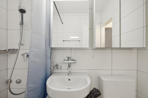 a white bathroom with a sink and a mirror at Pearlstay - City Center Workplace Balcony Washer in Winterthur