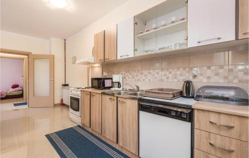 a kitchen with wooden cabinets and white appliances at Awesome Apartment In Bresca in Breza