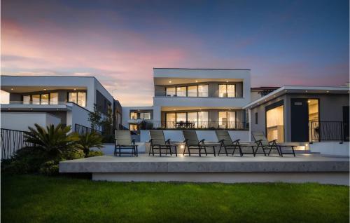 une maison avec des chaises assises devant elle dans l'établissement Gorgeous Home In Zidarici With Kitchen, à Vantačići
