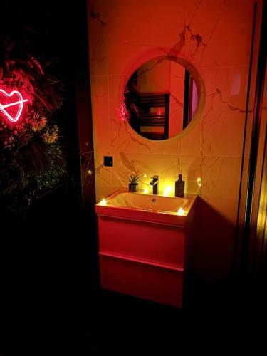 a bathroom with a red sink and a mirror at Love Room, Luna Spa in Saint-Ouen-lʼAumône