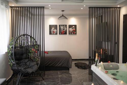 a bedroom with a bed and a tub and a chair at Love Room, Luna Spa in Saint-Ouen-lʼAumône