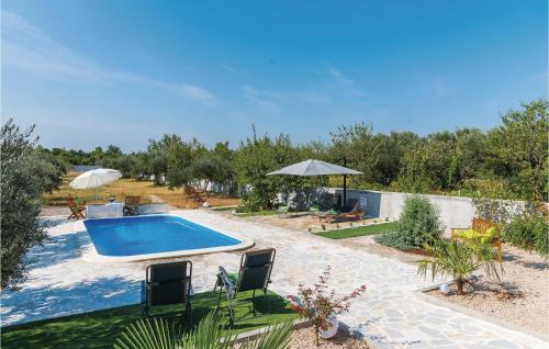 a swimming pool in a yard with chairs and umbrellas at Four-Bedroom Holiday Home In Skradin-Dubavice in Čulišić