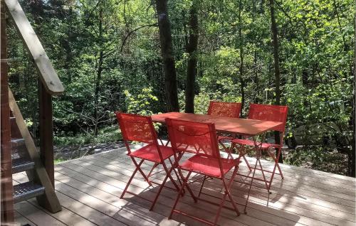 a wooden table and four red chairs on a deck at Lovely Home In Labaroche With Sauna in Labaroche