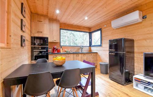 une cuisine avec une table avec des chaises et un réfrigérateur dans l'établissement Lovely Home In Labaroche With Sauna, à Labaroche