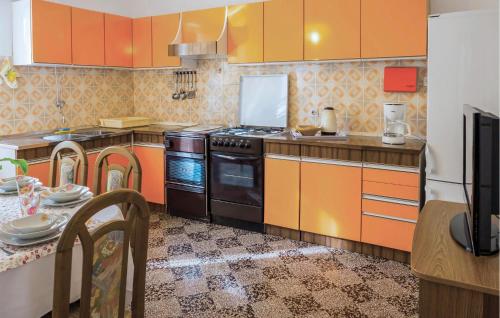 kuchnia z pomarańczowymi szafkami i kuchenką w obiekcie 3 Bedroom Gorgeous Home In Banjol w mieście Banjol