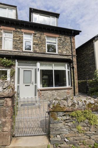 a brick house with a white door at Eller Cottage in Windermere
