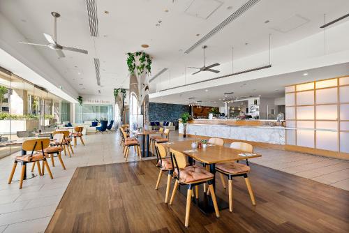 a restaurant with tables and chairs and a bar at Golfer's Paradise - Pelican Waters in Pelican Waters