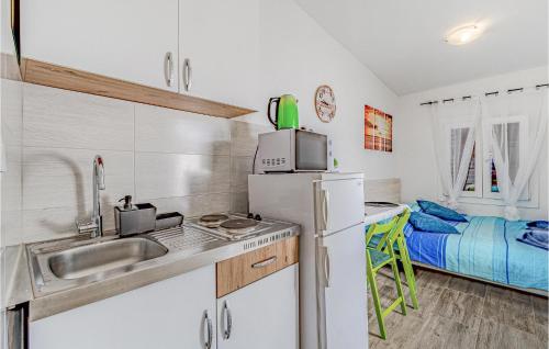 a kitchen with a sink and a refrigerator and a bed at Awesome Home In Potomje With Wifi in Potomje