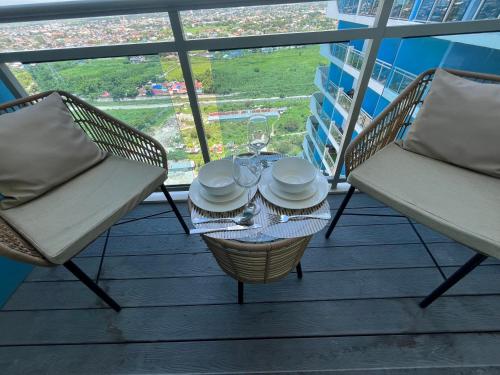 a table and chairs on a balcony with a view at Serenity Bali Condotel in San Fernando