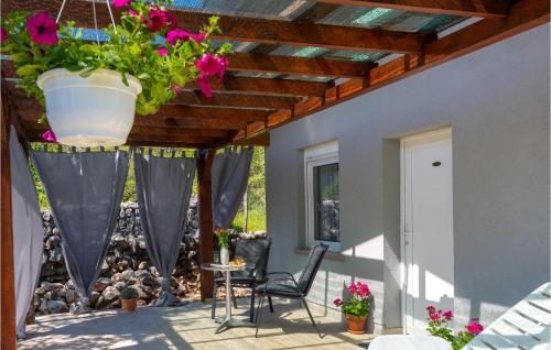 a patio with flowers in a pot hanging from a ceiling at Amazing Home In Risika With Kitchen in Risika