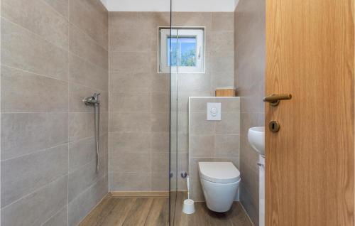 a bathroom with a toilet and a glass shower at Amazing Home In Risika With Kitchen in Risika