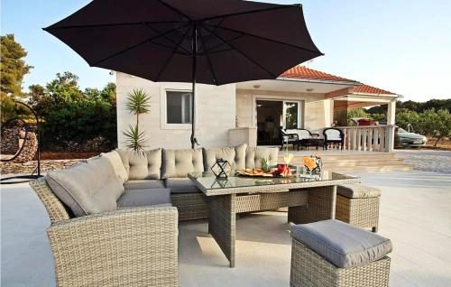 a patio with a couch and a table with an umbrella at Lovely Home In Supetar in Supetar