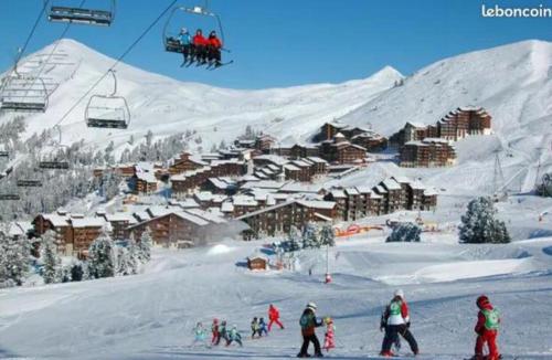 a group of people on a ski lift in the snow at 4-6 pers ski pieds Belle Plagne Les Gémeaux in La Plagne Tarentaise