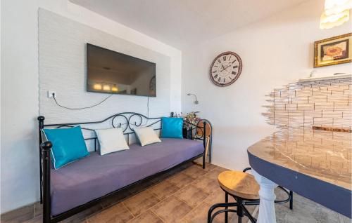 a room with a bed with blue pillows and a clock at Awesome Home In Nevidane With Wifi in Neviđane