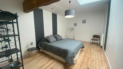 a bedroom with a bed and a wooden floor at Chambres et Gîtes Les Deux Chênes près de Bergerac in Le Fleix