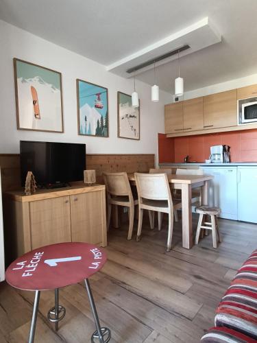 une cuisine et un salon avec une table et des chaises dans l'établissement 4-6 pers ski pieds Belle Plagne Les Gémeaux, à La Plagne Tarentaise