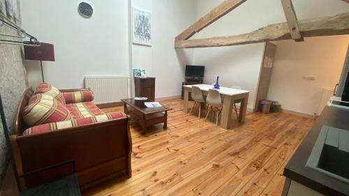 a living room with a couch and a table at Chambres et Gîtes Les Deux Chênes près de Bergerac in Le Fleix