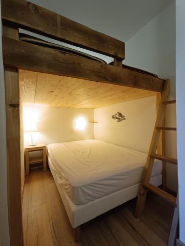 une chambre avec un lit superposé avec des draps blancs dans l'établissement 4-6 pers ski pieds Belle Plagne Les Gémeaux, à La Plagne Tarentaise