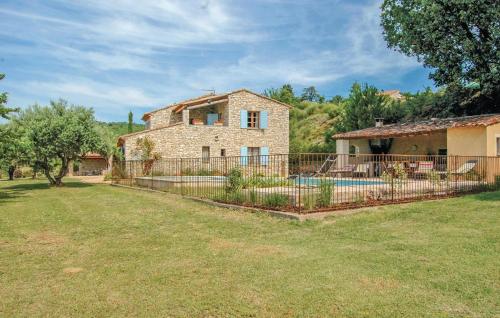 une maison en pierre avec une clôture en face d'une cour dans l'établissement Amazing Home In Sainte Croix-À-Lauze, à Sainte-Croix-à-Lauze